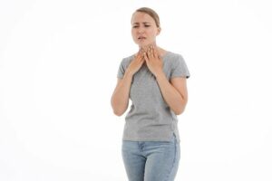 femme qui tient sa gorge de douleur