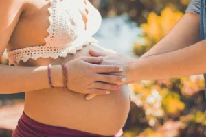 Femme enceinte qui tient les mains de son mari sur son ventre !