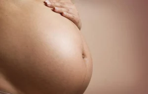 Femme enceinte proche du terme qui tient son ventre !