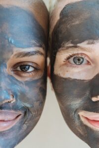 2 demi-visage de femmes avec de l'argile noire sur le visage