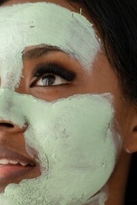 Visage de femme avec de l'argile verte sur le visage