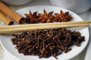 clous de girofle dans une assiette avec baguettes chinoises