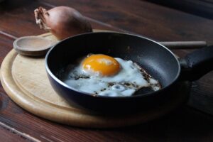 poëlle avec un oeuf sur le plat qui fait partie des astuces naturelles pour soulager l'arthrose